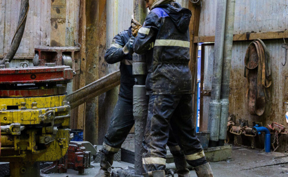 Two people working at an oil rig.