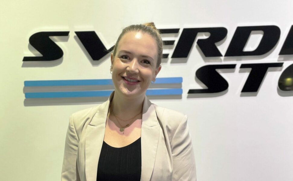 Christine Haugland in front of the Sverdrup Steel logo