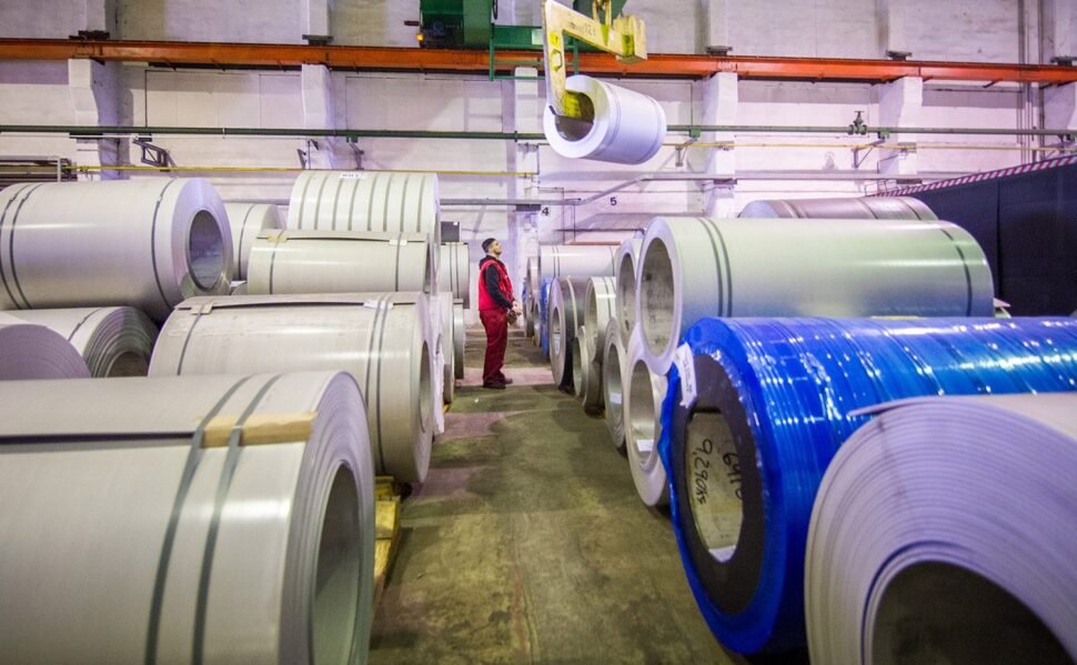 A person standing between steel coils